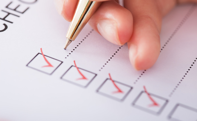 Cropped image of businesswoman writing on checklist